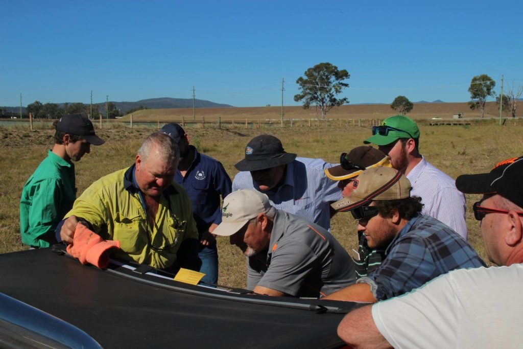 Farmers gather around the laptop at the Laidley agricultural drone demo to see what the UAV is capturing